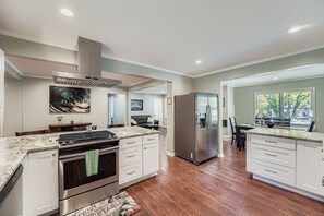 Una cocina moderna con refrigerador de acero inoxidable, horno empotrado y encimeras de granito.
