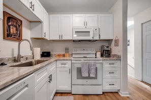 A modern kitchen with white cabinetry, a built-in microwave, a coffee maker, and a toaster. - Osceola's Oasis-Townhome with 3 bedrooms and 2.5 bathrooms. Walk to FSU/DOAK. (Tallahassee)