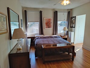 A bedroom with a bed, bedside tables, a desk, a lamp, and a window. - Masters Rental: 3-bedroom house 1 block to Press Headquarters 1 mile to course (Augusta)