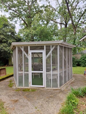 A small, enclosed garden structure with a door and windows, surrounded by grass and trees. - Masters Rental: 3-bedroom house 1 block to Press Headquarters 1 mile to course (Augusta)