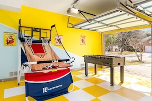 A sports room with a basketball hoop, foosball table, and a checkered floor. - Family Fun, Heated Pool, Slide, Hot Tub, Game Room (San Antonio)