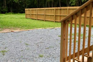A wooden deck with a gravel path leading to a wooden fence. - Serene 2BR + Study, Min to NoDa & Uptown (Charlotte)