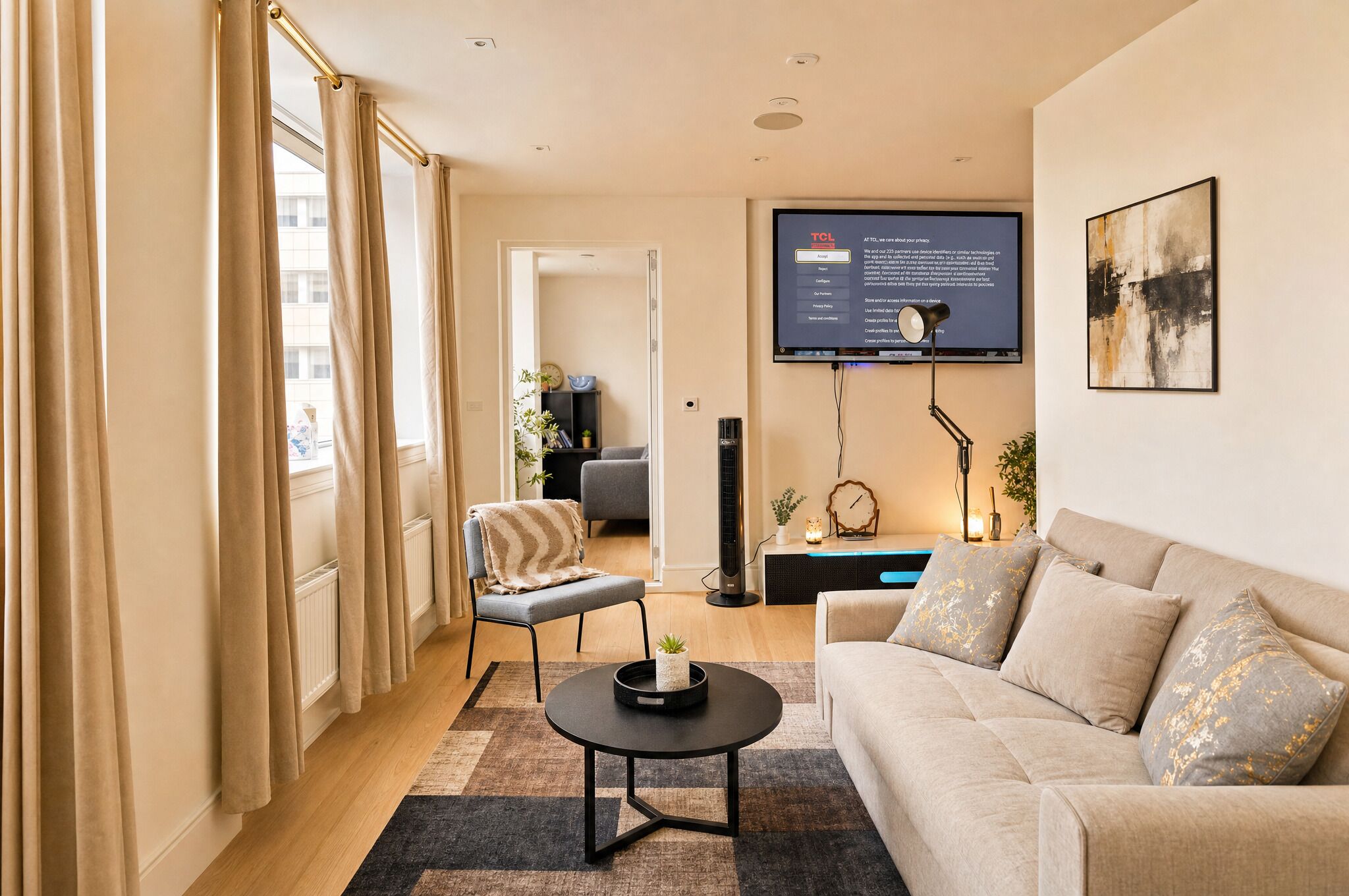 A modern living room with a sofa, a coffee table, and a TV mounted on the wall.