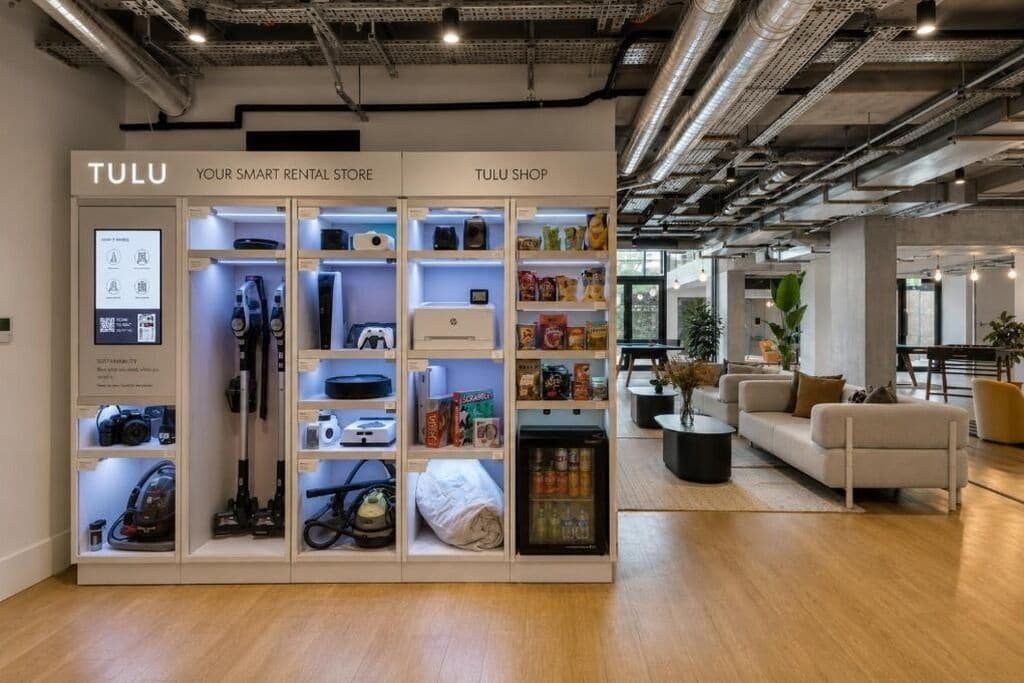 A TULU rental store with various items on display including cameras, cleaning equipment, and snacks.