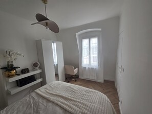 Et soveværelse med en seng, et skab, et skrivebord og en stol.