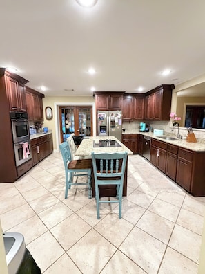 Una cocina con armarios de madera, una isla central y una mesa de comedor con sillas.