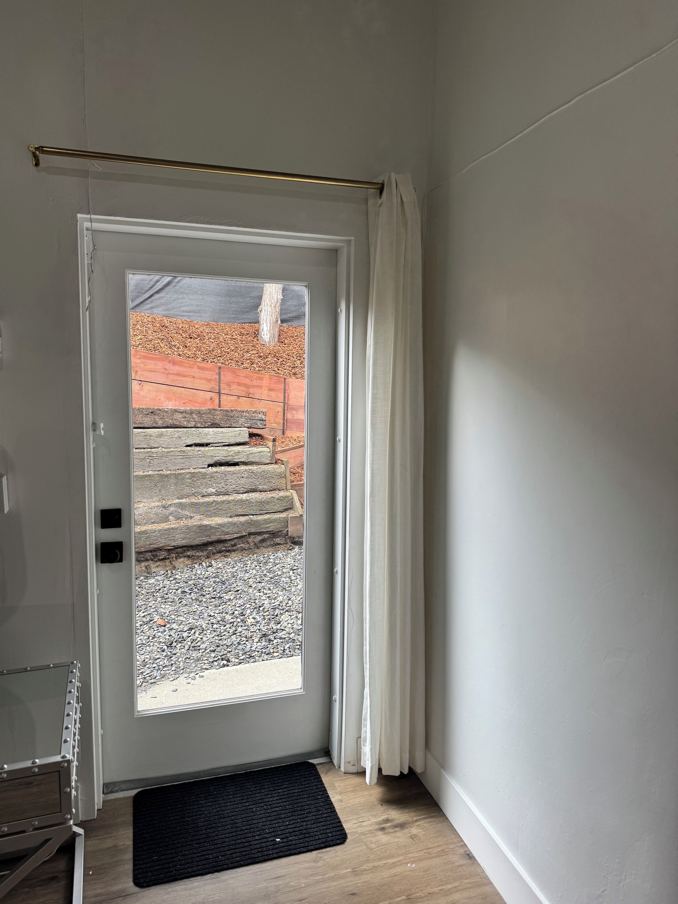 A door with a view of a wooden staircase leading outside.