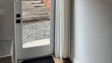 A door with a view of a wooden staircase leading outside.