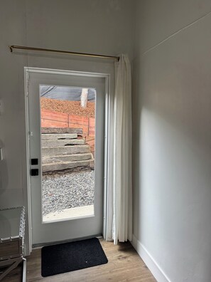 A door with a view of a wooden staircase leading outside.