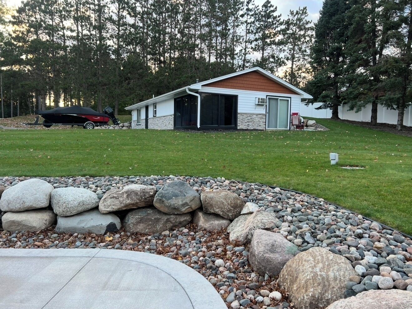 A house with a garage, a lawn, and a rock garden.