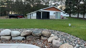 A house with a garage, a lawn, and a rock garden.