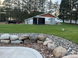 A house with a garage, a lawn, and a rock garden. - Spacious Lakefront Retreat, with Room for Everyone. Cabin and Event Center. (Isanti)
