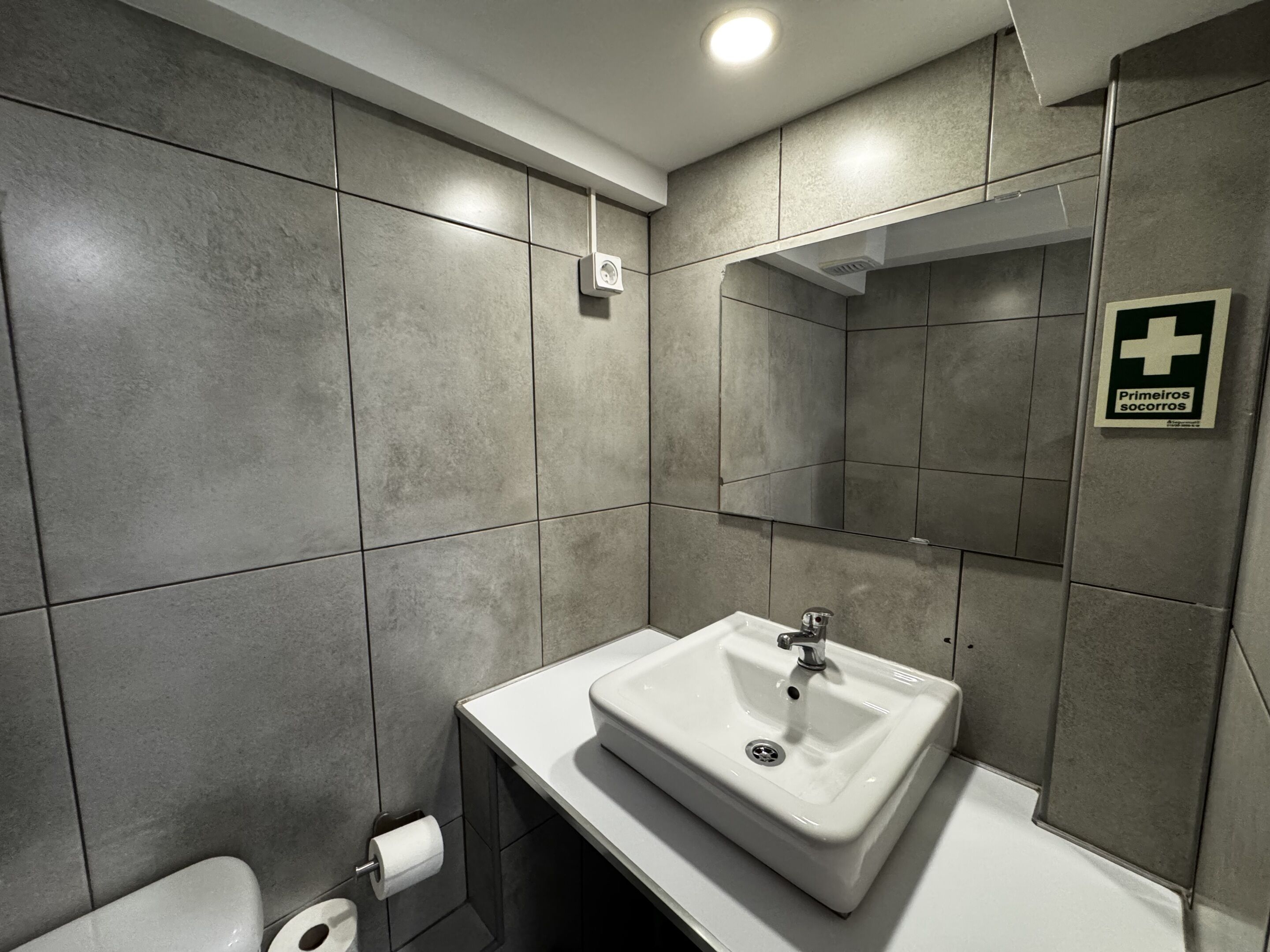 Ein modernes Badezimmer mit Waschbecken, Toilette und Spiegel.