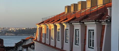 Una hilera de edificios con techo de tejas rojas, paredes blancas y numerosas ventanas.