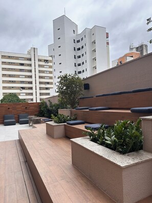 An outdoor seating area with built-in planters and seating. - Cozy 1-bedroom apartment in marvelous Fortaleza with AC and gym (Fortaleza)