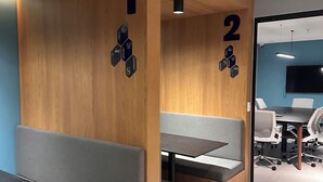 Moderni toimistotila, jossa on kaksi erillistä oleskelualuetta, ja molemmat on merkitty numerolla.