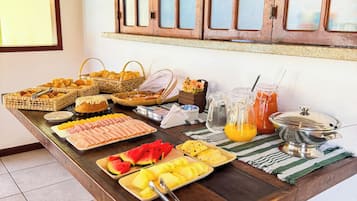A breakfast buffet with various food items and a fruit bowl.