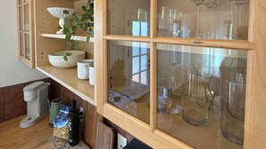 A kitchen with wooden cabinets, a coffee maker, and a black countertop. - Charming Furnished Casita with Private Yard in South Park/Golden Hill (San Diego)
