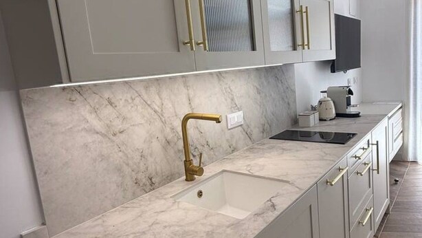 A modern kitchen with marble countertops, gold handles, and a built-in sink. - La Casona de les Arts 1 - Oceanográfic (València)