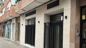 A building facade with a modern design, featuring large windows and a metal gate. - La Casona de les Arts 1 - Oceanográfic (València)