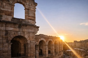 An ancient stone structure with multiple arches and a crowd below. - View of the Arena and Piazza Bra (Verona)