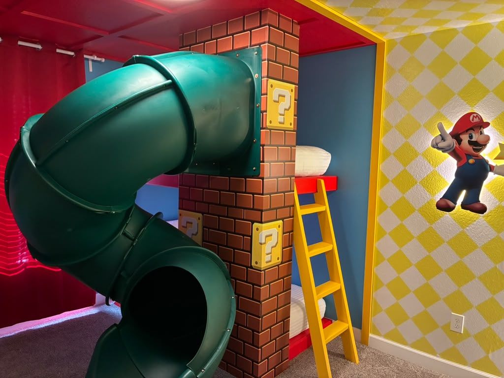 A children's play area with a slide, a ladder, and a Mario character decoration.