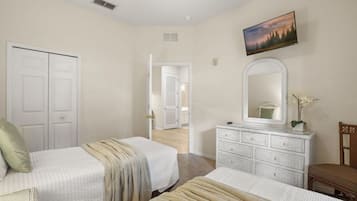 A bedroom with two beds, a dresser, a mirror, and a painting on the wall.