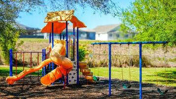 A playground with a slide, swings, and a climbing structure.