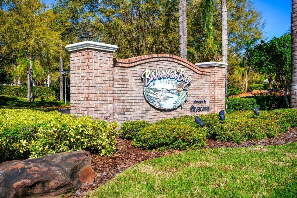 A brick wall with a sign for 'Bahama Bay Resort' and a logo.