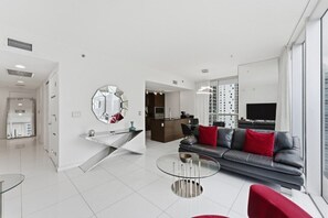 Ein modernes Wohnzimmer mit einem Glastisch, einer roten Sofaausstattung und einem großen Spiegel an der Wand.