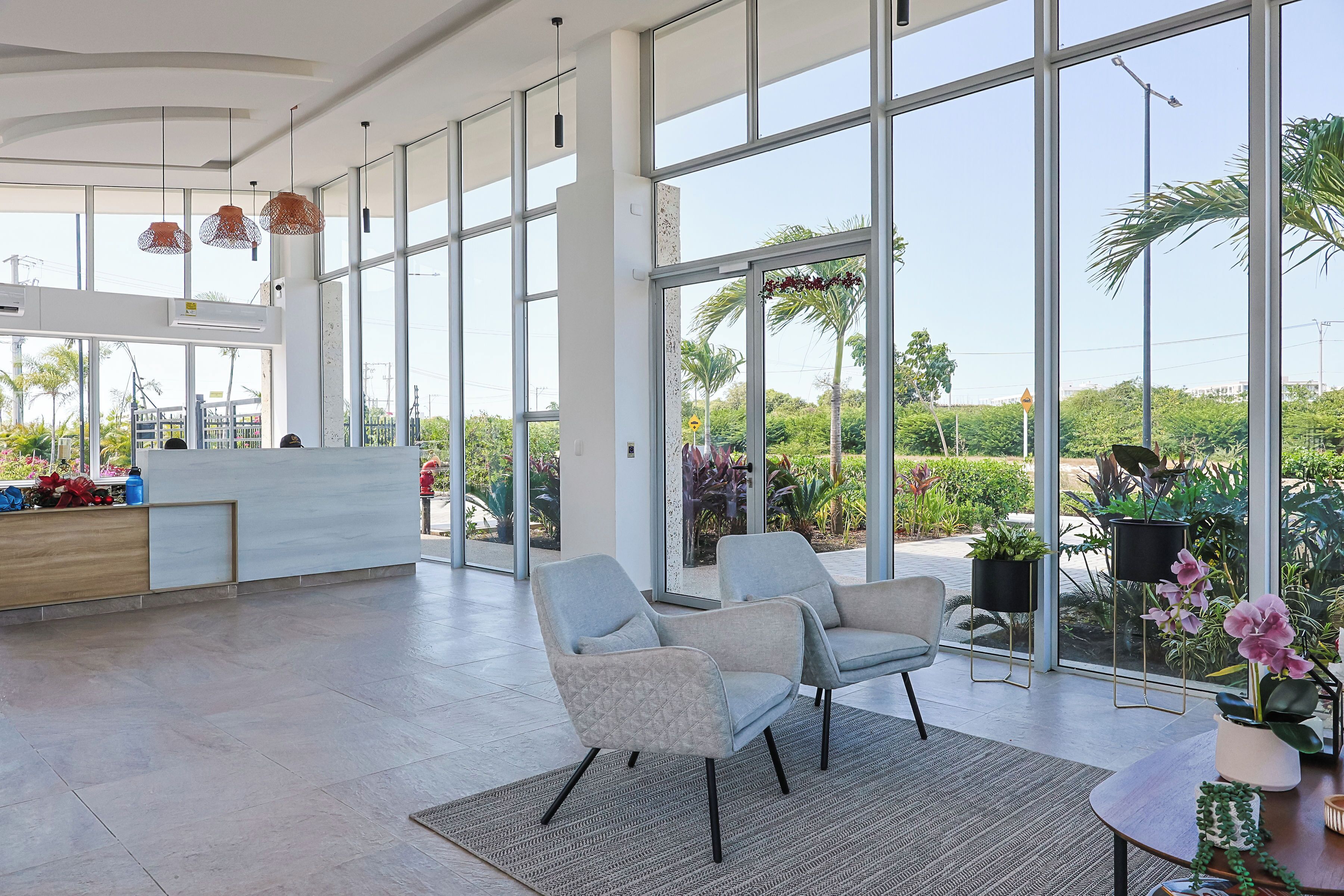 A spacious lobby with large windows, a reception desk, and seating area.
