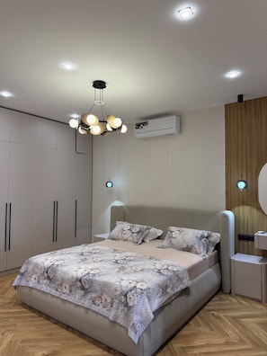 A modern bedroom with a large bed, a ceiling light fixture, and an air conditioning unit. - Seoul Riverside apartment (Tashkent)