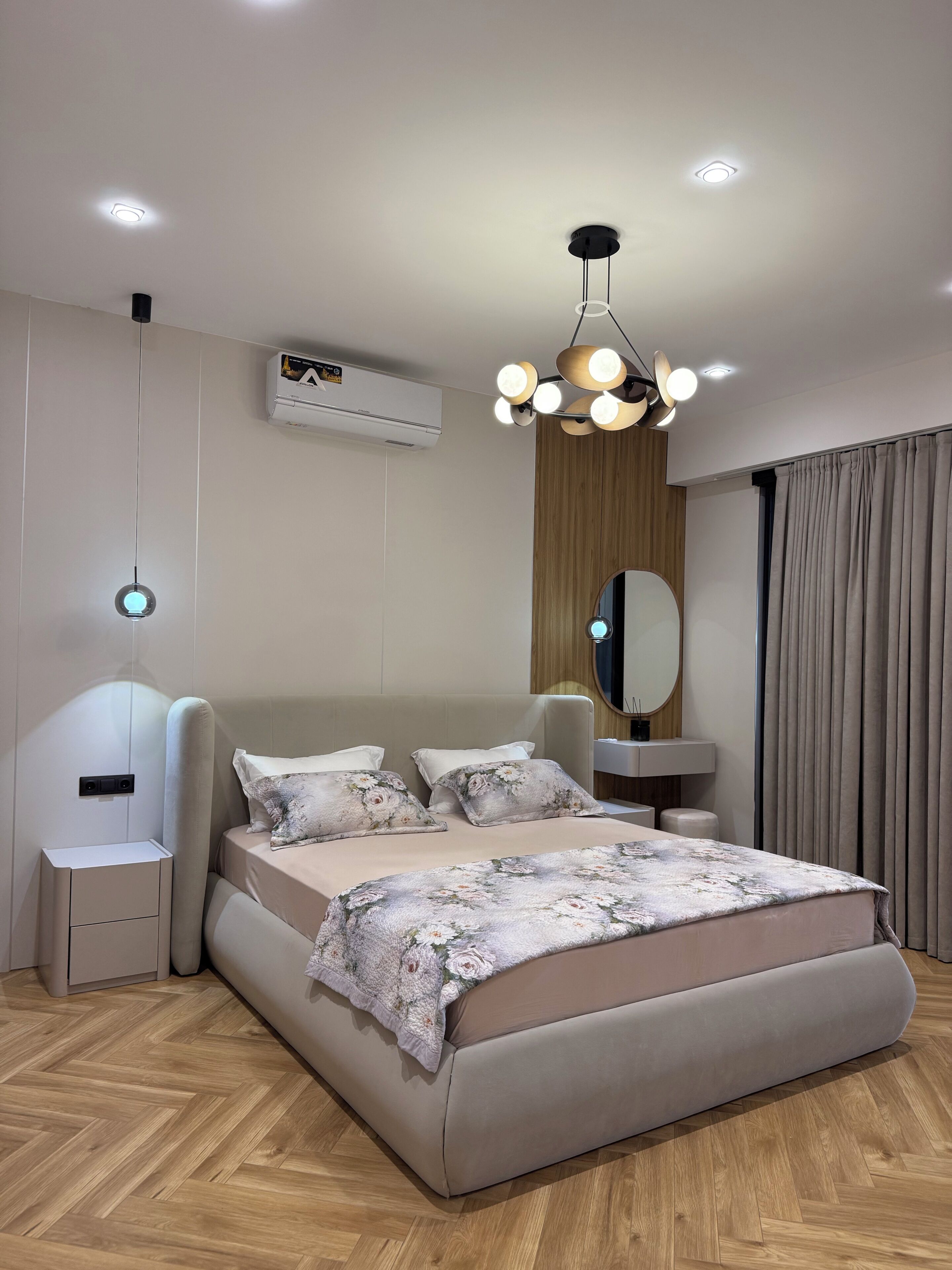 Una camera da letto moderna con un letto grande, comodini, un lampadario e un condizionatore d'aria.