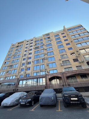 A multi-story building with a parking lot in front. - Seoul Riverside apartment (Tashkent)