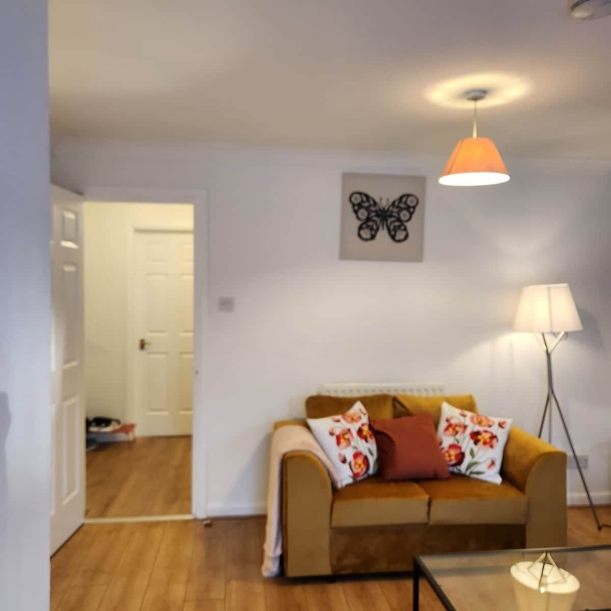 Una sala de estar con un sofá, una lámpara y un candelabro.