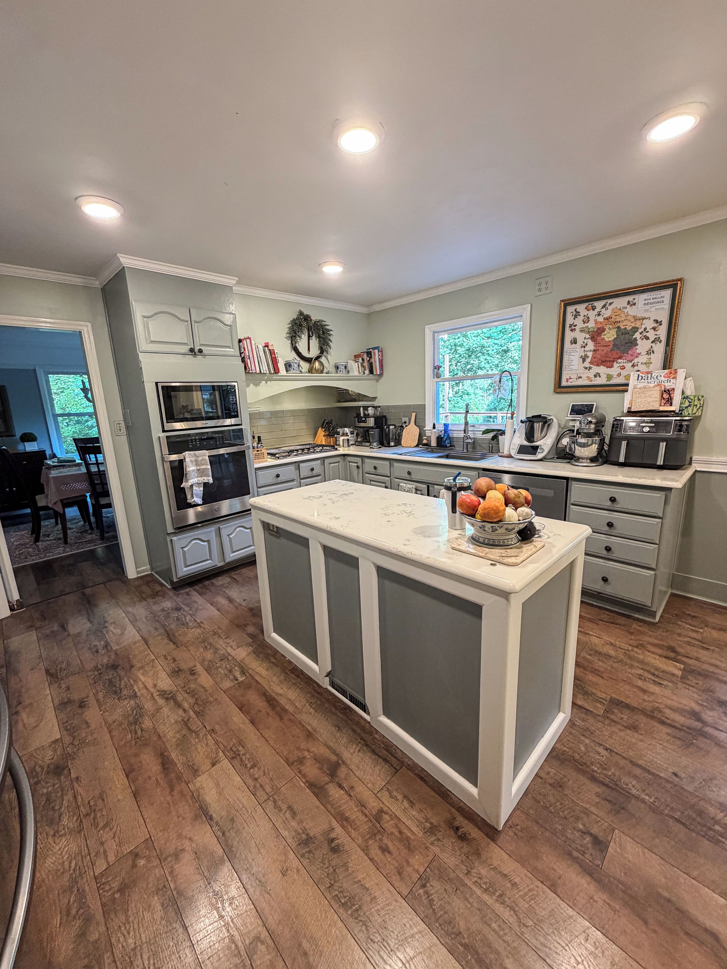 A kitchen with a central island, built-in appliances, and a window providing natural light.