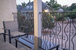A balcony with a metal railing, a chair, and a small table. - 3 King Beds with En Suite Bathrooms and Private Shuttle to Square & Stadium (Oxford)