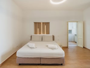 A bedroom with a bed, two pillows, a bedside table, and a wall-mounted light fixture. - Casa vacanze al teatro by Interhome (Carrara)