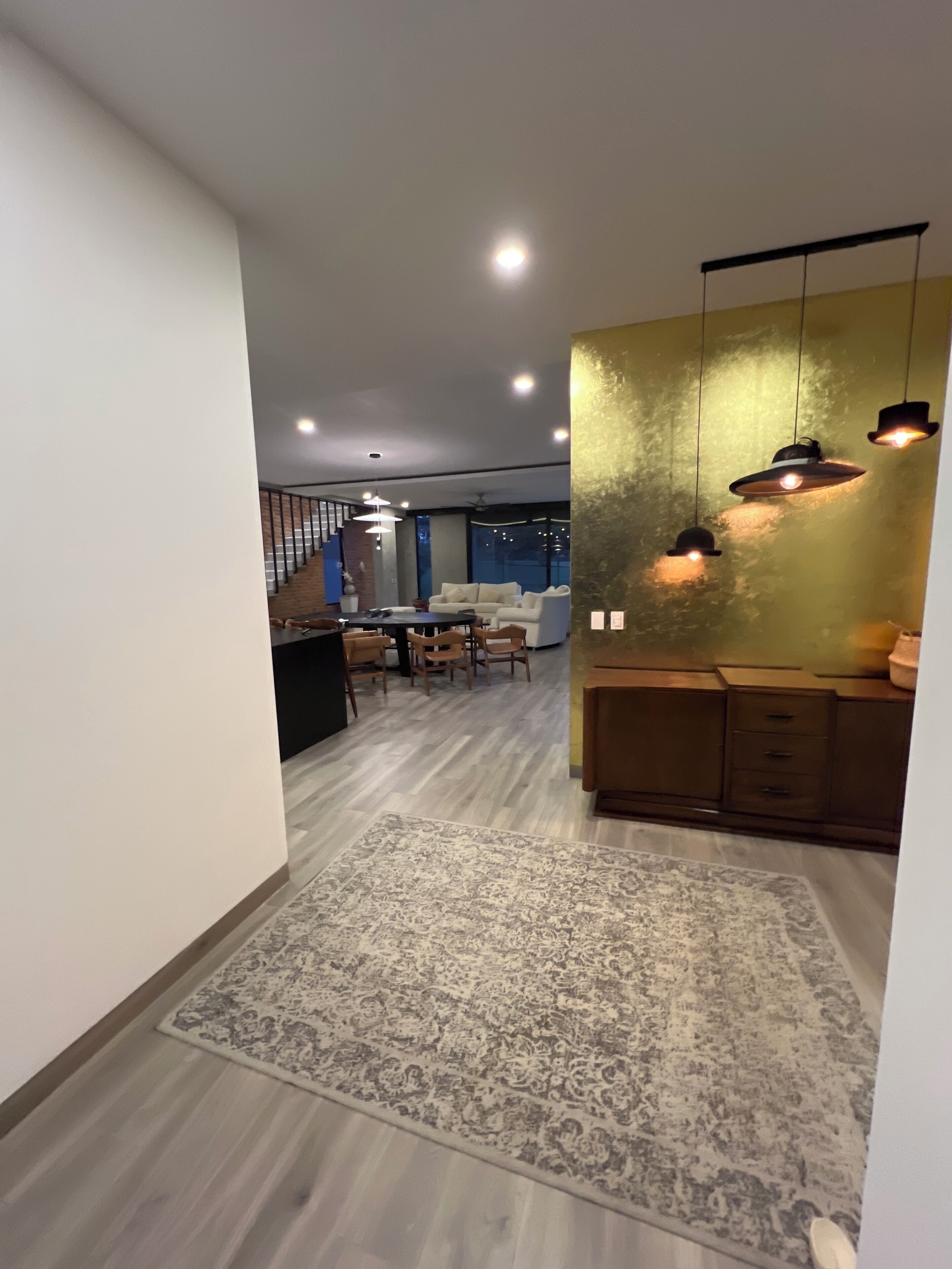 A modern interior with a staircase, a dining area, and a kitchen.