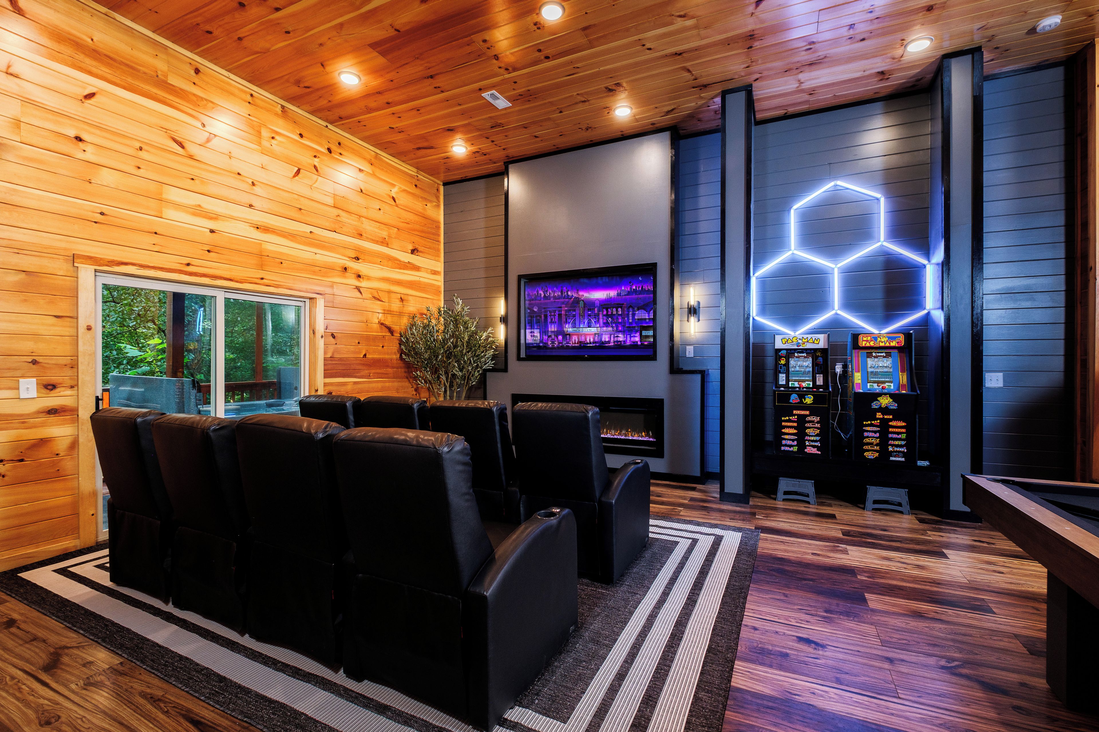 A modern interior with wooden walls, a fireplace, gaming machines, and a seating area.