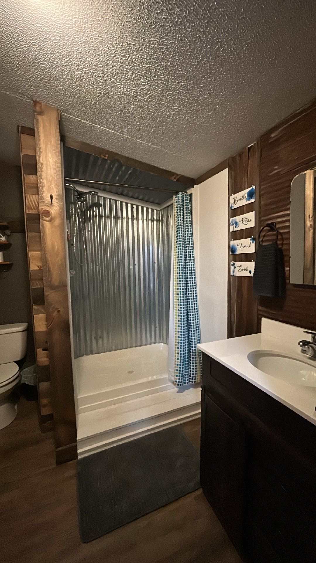 A bathroom with a bathtub, shower curtain, and a vanity with a sink.
