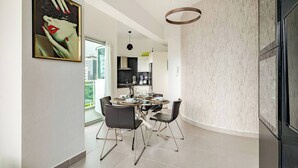 Eine moderne Küche mit Essbereich, großem Fenster und einer Pendelleuchte.