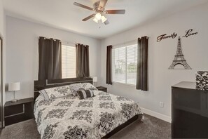 A bedroom with a bed, curtains, a ceiling fan, a wall decoration of the Eiffel Tower, and a bedside table. - Extraordinary 6-bedroom house with in vibrant South west Las Vegas (Las Vegas)