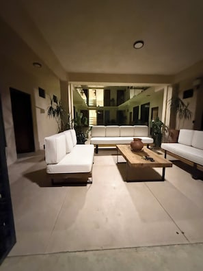Una sala de estar moderna con un sofá blanco, una mesa de centro de madera y plantas en macetas.