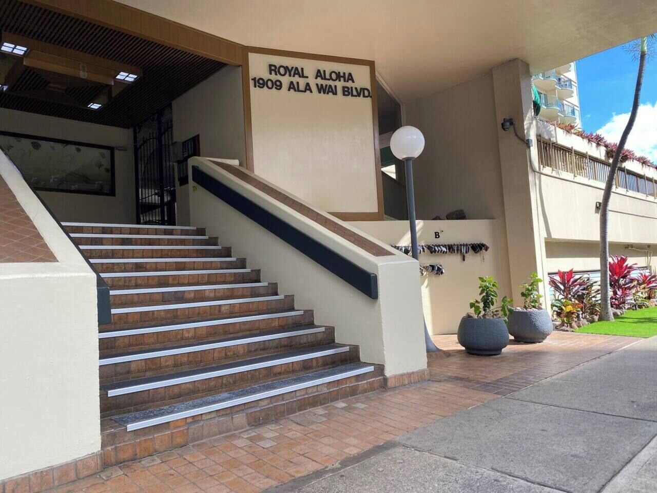 A staircase leading to a building with a sign reading 'ROYAL ALOHA 1909 ALA WAII BLVD.'