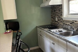 A compact kitchen with white cabinets, a black countertop, a stainless steel sink, and a microwave. - Aparment Downtown Sarasota 2br, 2ba, Petfriendly Beaches, 5 People (Sarasota)