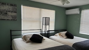 A room with two beds, a standing lamp, and a poster on the wall. - Aparment Downtown Sarasota 2br, 2ba, Petfriendly Beaches, 5 People (Sarasota)
