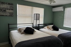 A room with two beds, a standing lamp, and a poster on the wall. - Aparment Downtown Sarasota 2br, 2ba, Petfriendly Beaches, 5 People (Sarasota)