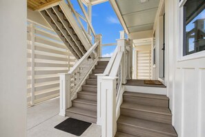Eine Treppe mit weißen Geländern und einer schwarzen Matte am Fuß.