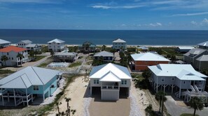 Un área residencial costera con casas de techos a dos aguas y una playa al fondo.